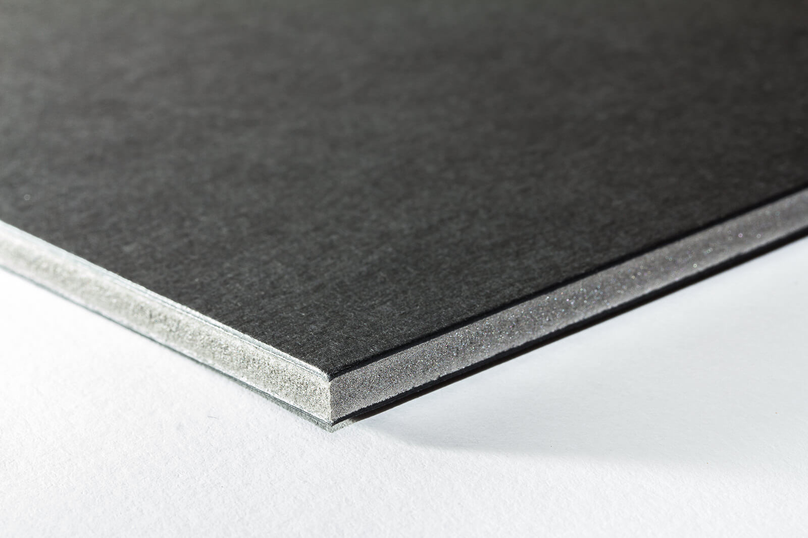 Eine Nahaufnahme der Oberflächenstruktur einer schwarzen Kapa-Graph Leichtschaumplatte