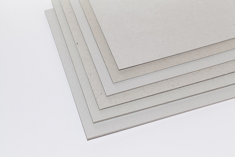 Ein Stapel sechs verschieden Dicken hellgrauen Graupappen aus Recycling-Material